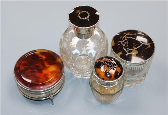 A George V silver and tortoiseshell mounted glass scent bottle, two similar toilet jars and a 1920s silver and tortoiseshell box.